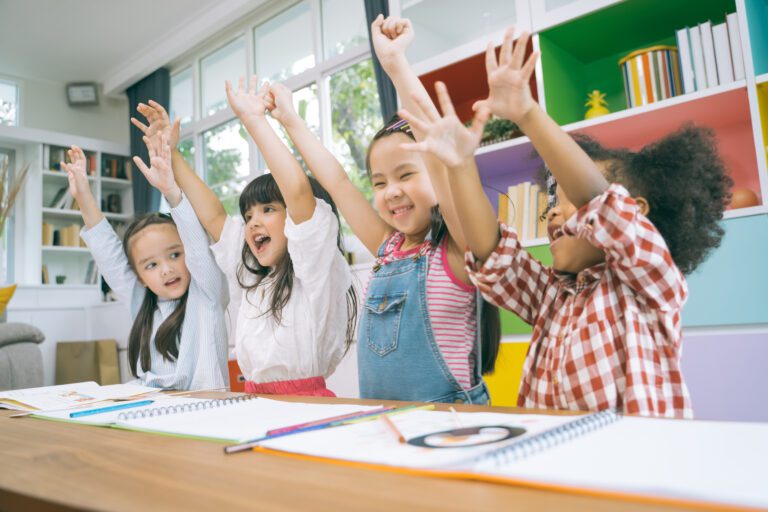 Group of little preschool kids hands up in class 
